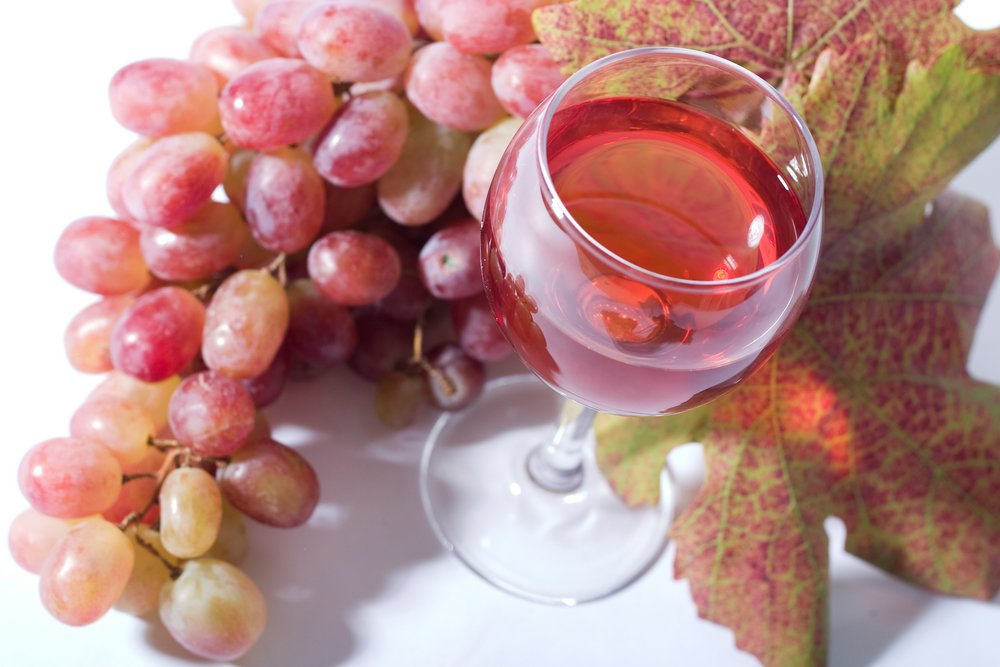 Картинка: бокал розового вина с кисточкой винограда