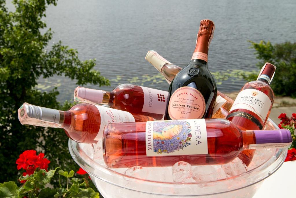 На фото бутылки розового вина на фоне моря
