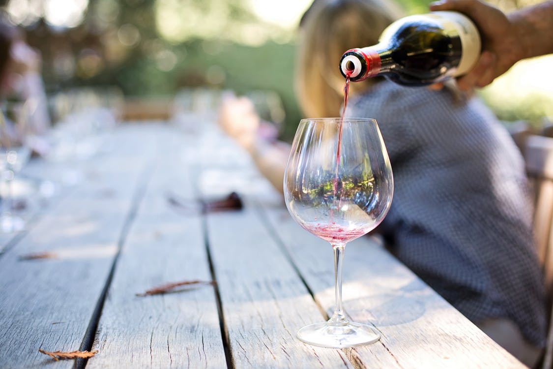 Фотография: аккуратно наливается вино из бутылки в бокал