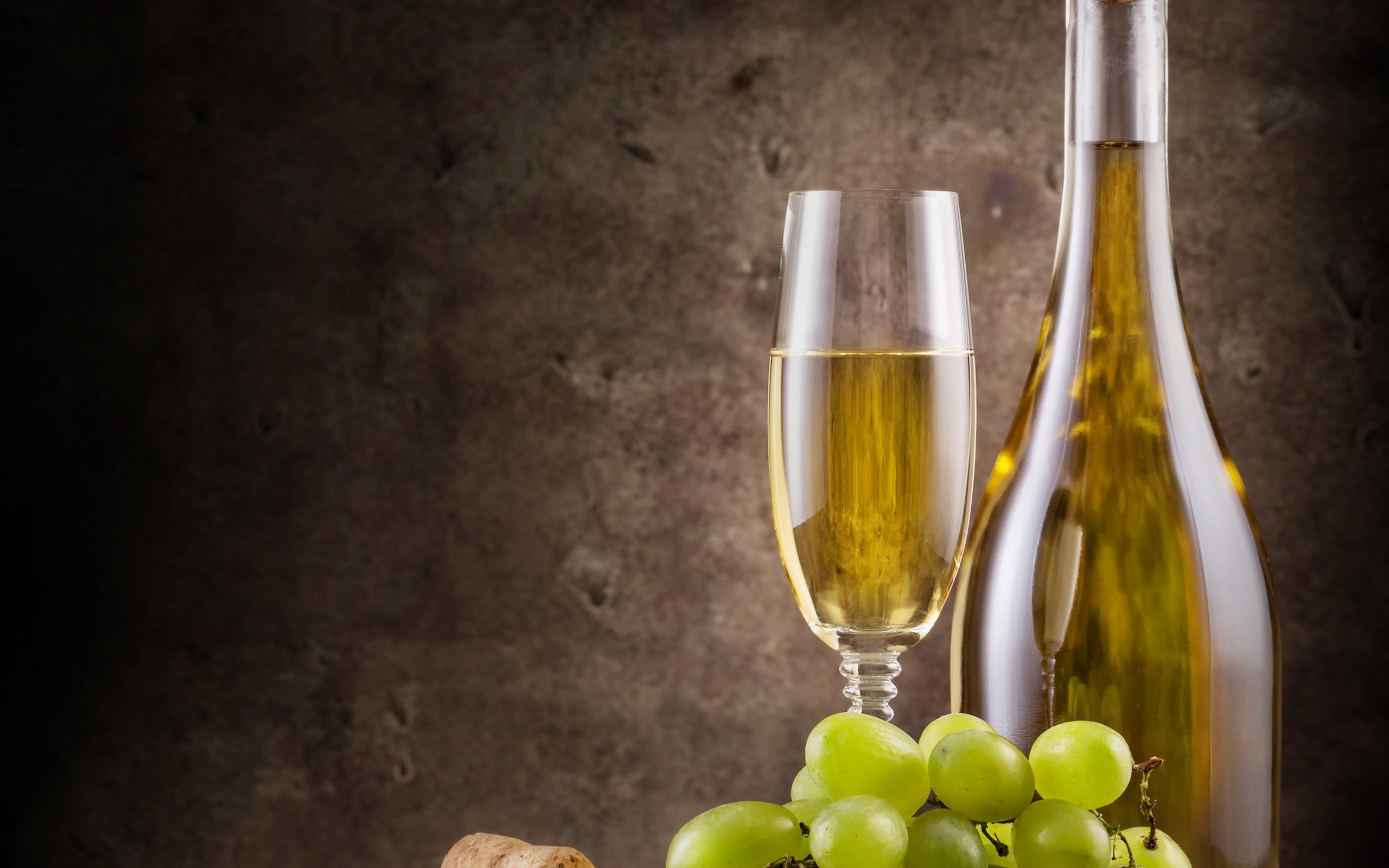 Натюрморт: бутылка белого вина, бокал и виноград