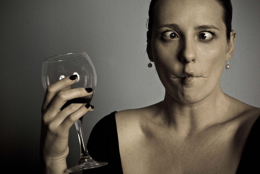 На фото показана гримаса девушки, произошедшая от вкуса некачественного винного напитка