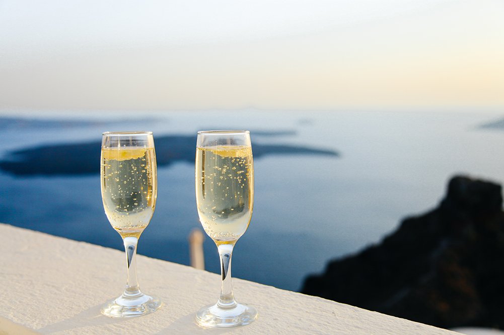 На фотографии бокалы игристого вина на фоне голубого моря