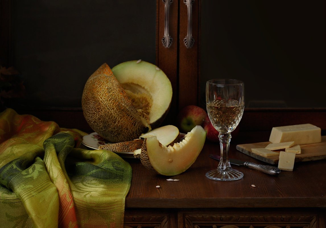 Натюрморт: на столе дыня, сыр и бокал вина