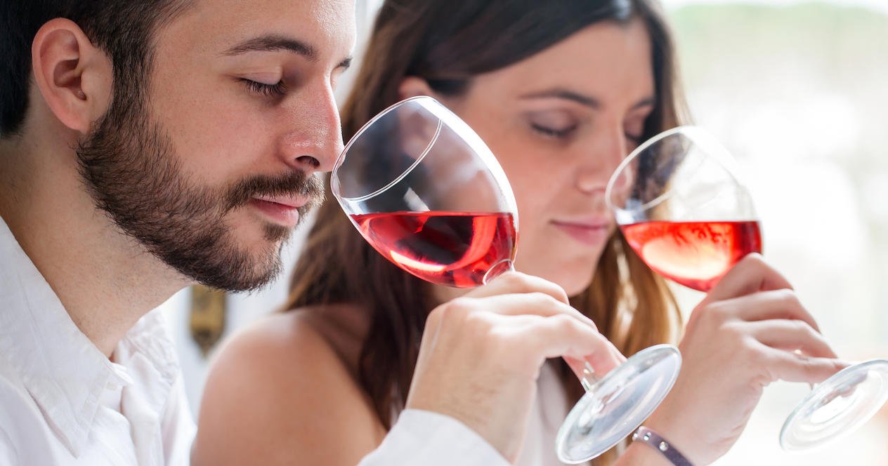На фото молодая пара наслаждается дегустацией винного напитка. Каковы на вкус танины в вине?