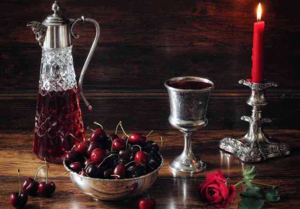 Натюрморт: хрустальный графин с вином, бокал, свеча на подсвечнике и ягоды черешни с веточкой розы