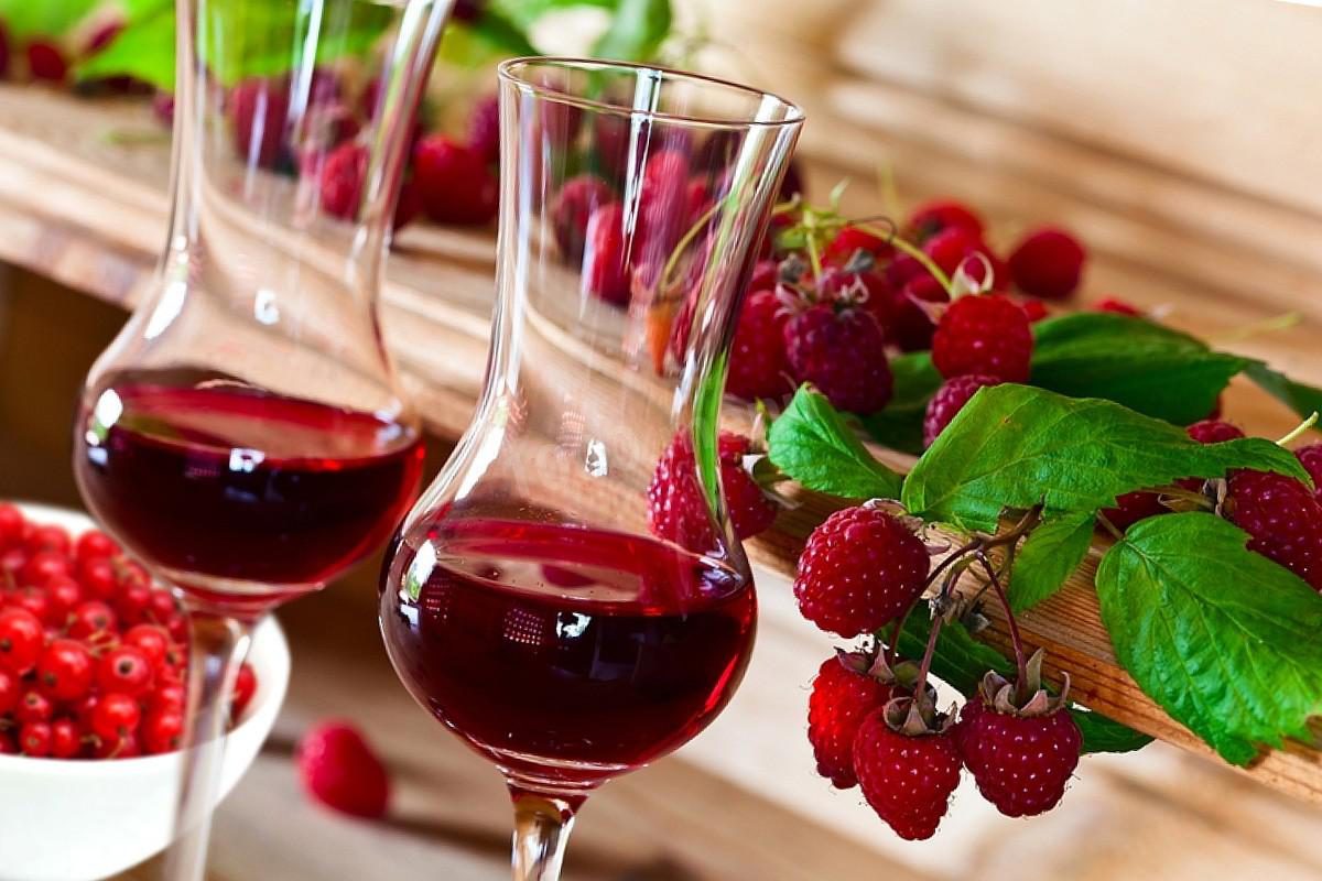 На фотографии: вино из красной смородины в бокалах на основе малины
